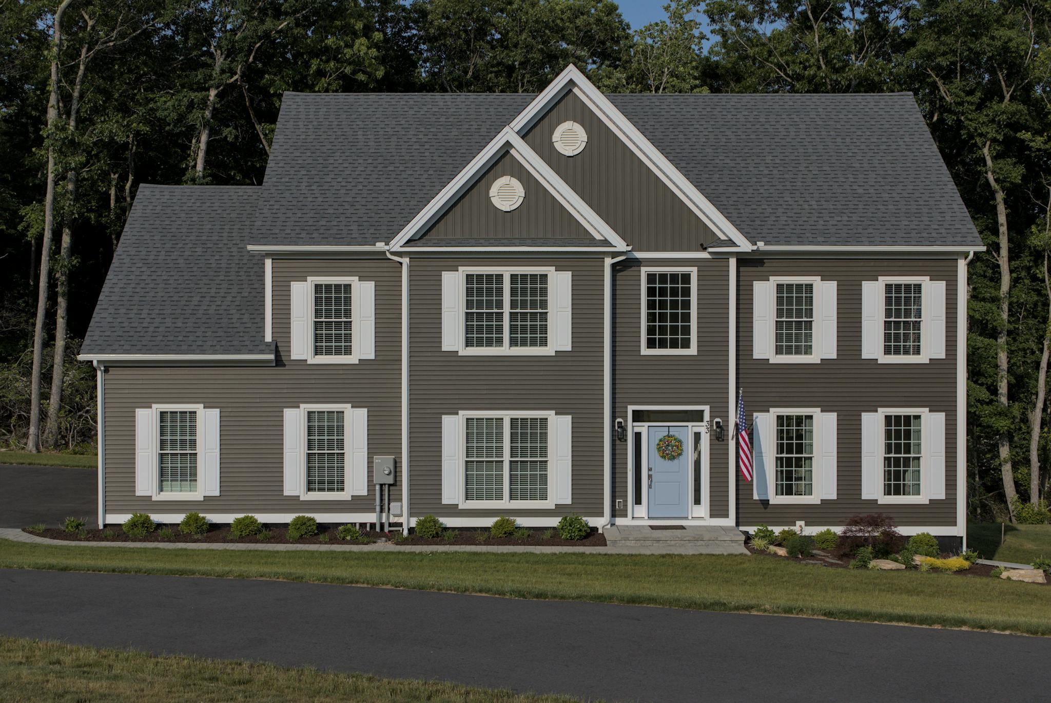 Front view of a classic suburban American house with manicured lawn and driveway.